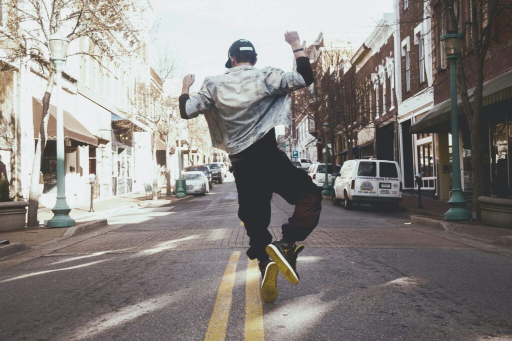 Young man dancing on the road in a city.